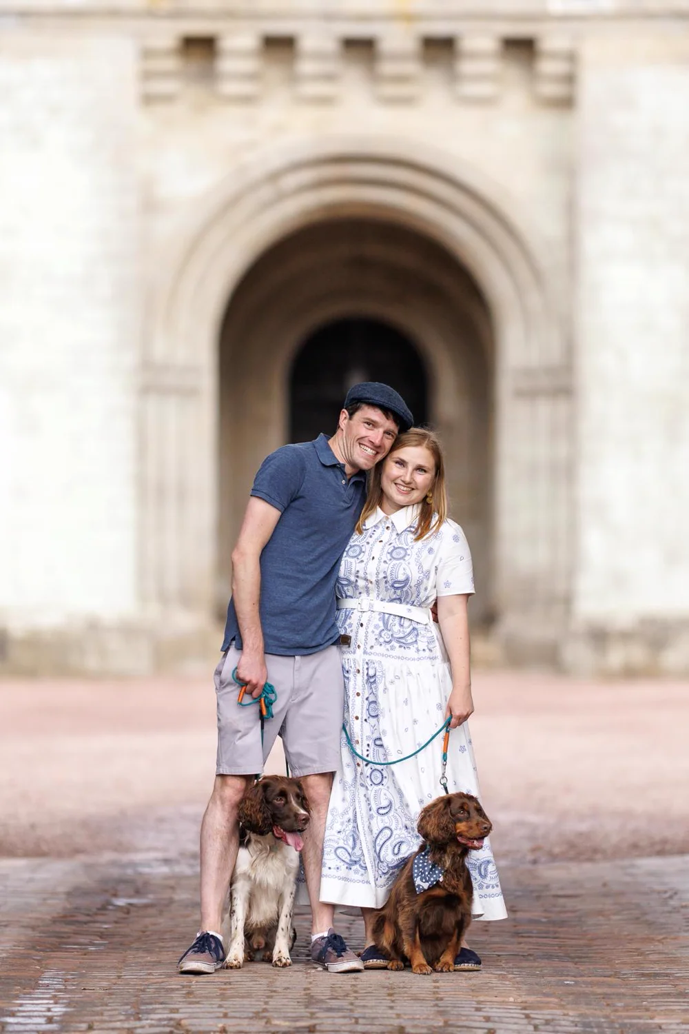 A bride and groom with their two spaniels, Xena and Casper, at their wedding venue